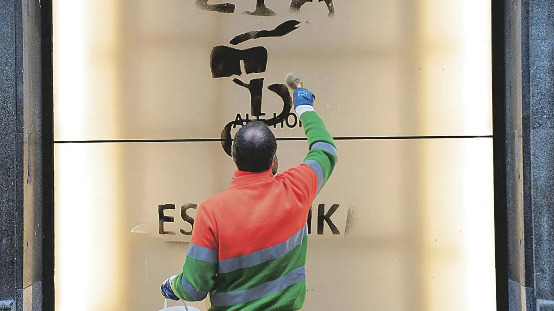 Un trabajador del servicio de limpieza quita una pintada reivindicando a ETA en Bilbao, dos días después de que la banda anunciaran su disolución/ Reuters