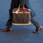 Un asistente porta un bolso de Louis Vuitton camino a la Casa Blanca el pasado mes de febrero