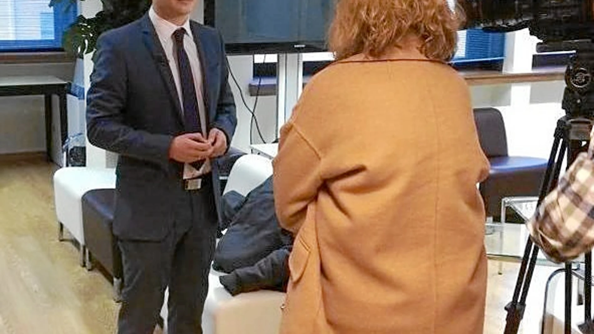 Saúl N. Amado, presidente de la Asociación Projoven de Valladolid, durante una entrevista en televisión. A la derecha, cartel de la mesa redonda que se celebra mañana en la Universidad Europea Miguel de Cervantes (UEMC) de la capital vallisoletana