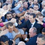 El presidente sirio Bachar al Asad saluda a simpatizantes a su llegada para el rezo en Damasco