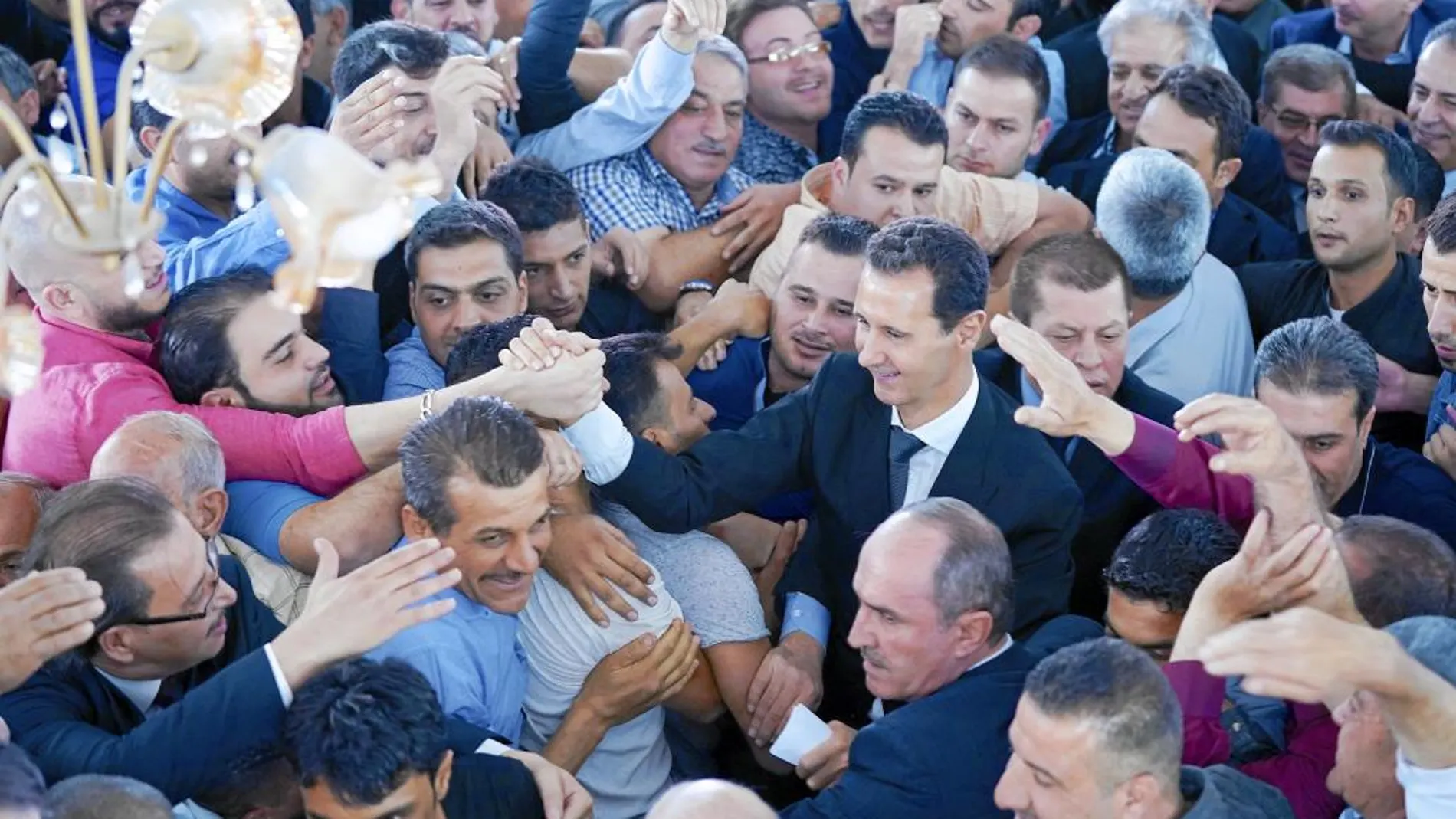El presidente sirio Bachar al Asad saluda a simpatizantes a su llegada para el rezo en Damasco