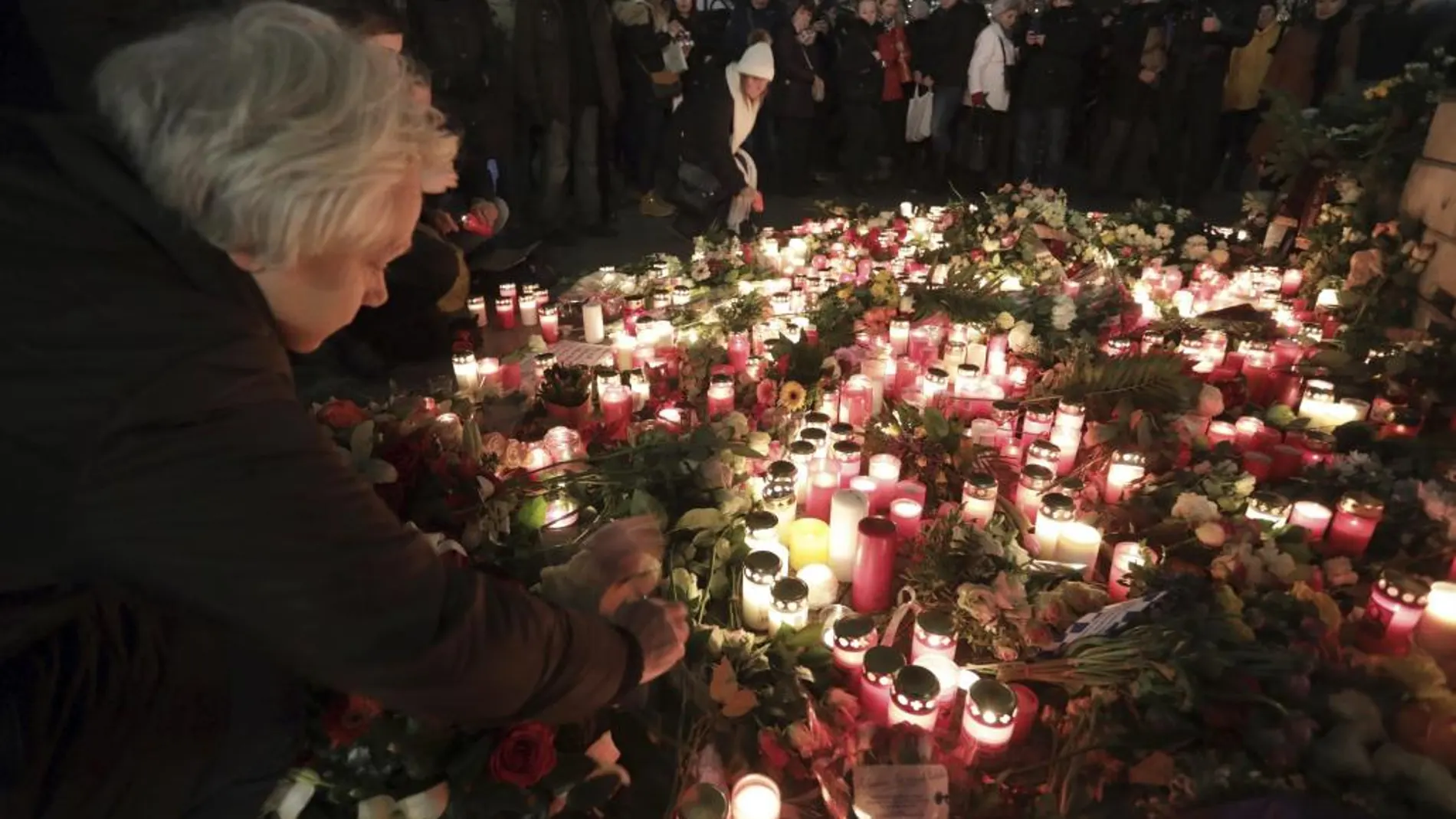 Una mujer enciende una vela en el lugar del atentado
