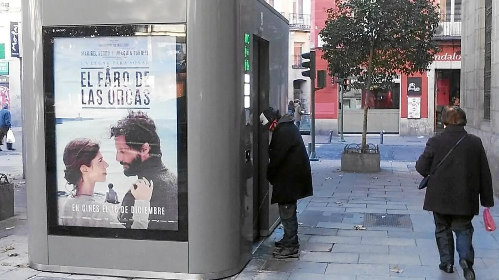 Imagen remitida por los comerciantes de Plaza Mayor al concejal de Centro en la que se ve a un indigente orinando en la puerta de un aseo municipal