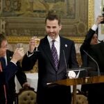 El Príncipe de Asturias, Felipe de Borbón (c), brinda junto al director ejecutivo de la Comisión de Evaluación del Comité Olímpico Internacional (COI), el suizo Gilbert Felli (i), y el francés Guy Drut (d), al inicio de la cena ofrecida hoy en el Palacio Real