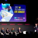 El jefe de la unidad de cirugía gastrointestinal del Hospital Clínic de Barcelona, Antonio de Lacy (d), monitora y dirige a su equipo desde el auditorio del MWC, durante una cirugía de extracción de un tumor en el colon de un paciente a través de una tableta conectada por tecnología 5G con un nuevo quirófano construido en el Hospital Clínic de Barcelona. EFE/Enric Fontcuberta