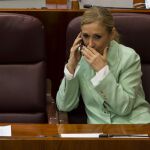 La presidenta de la Comunidad de Madrid, Cristina Cifuentes, habla por teléfono durante el Pleno de la Asamblea