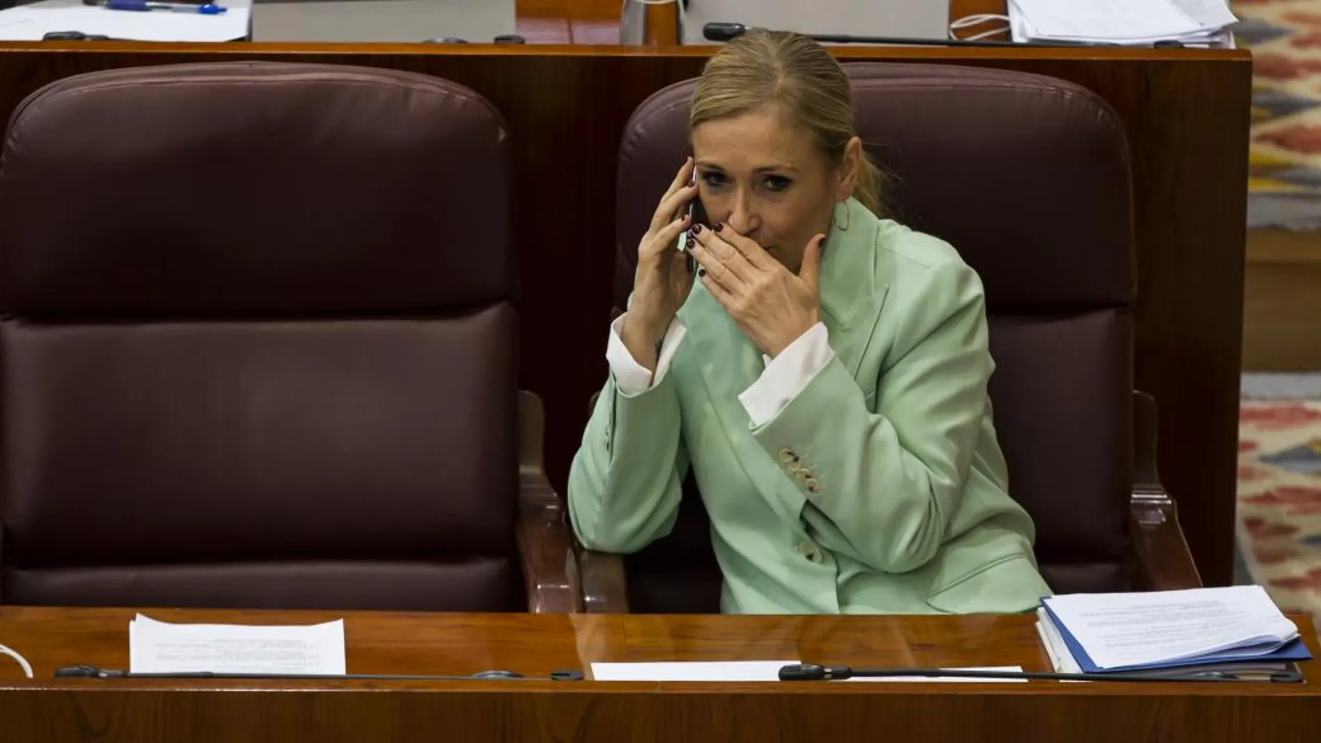 La presidenta de la Comunidad de Madrid, Cristina Cifuentes, habla por teléfono durante el Pleno de la Asamblea