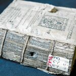 Estas fotografías muestran dos libros antiguos, –el primero atravesado por una bala y el segundo todavía con una de ellas «prensada» entre sus páginas– que en la actualidad se conservan en la biblioteca histórica de la Universidad Complutense