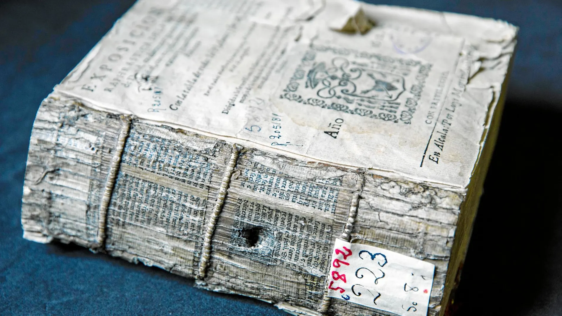 Estas fotografías muestran dos libros antiguos, –el primero atravesado por una bala y el segundo todavía con una de ellas «prensada» entre sus páginas– que en la actualidad se conservan en la biblioteca histórica de la Universidad Complutense