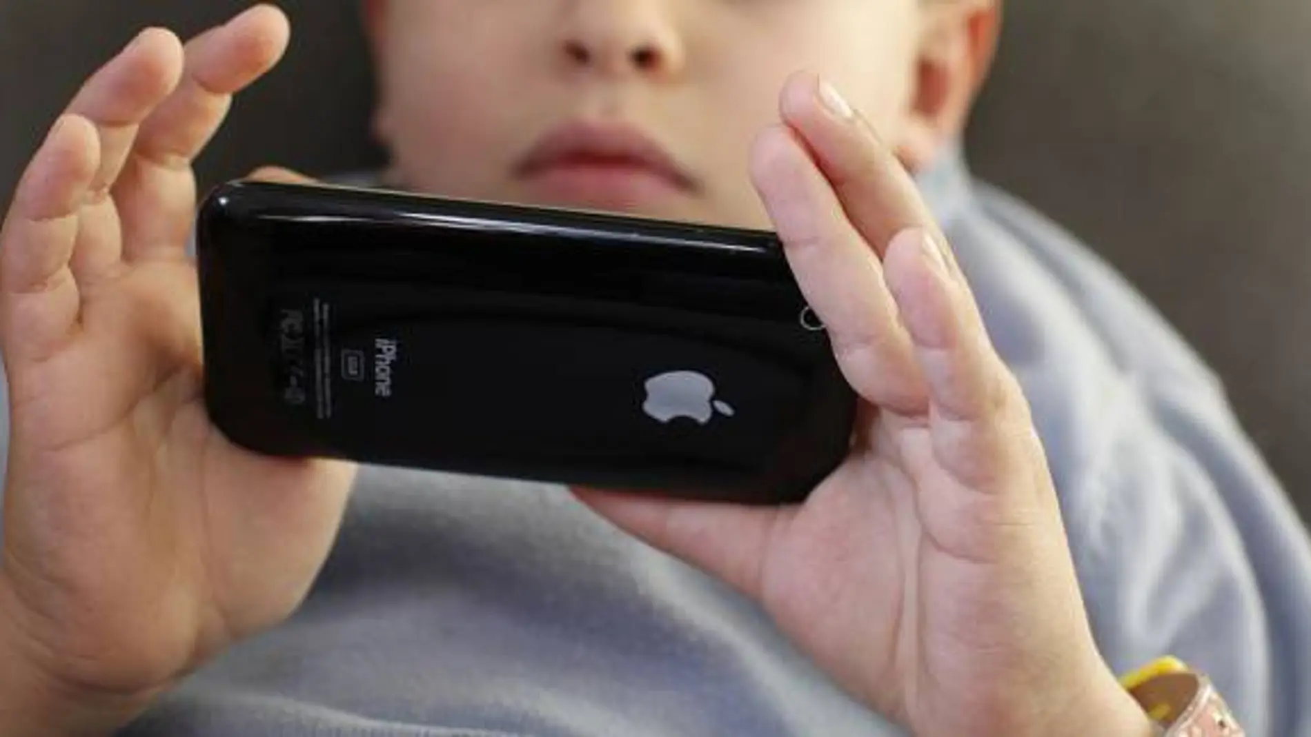 Un niño asiático utiliza un iPhone