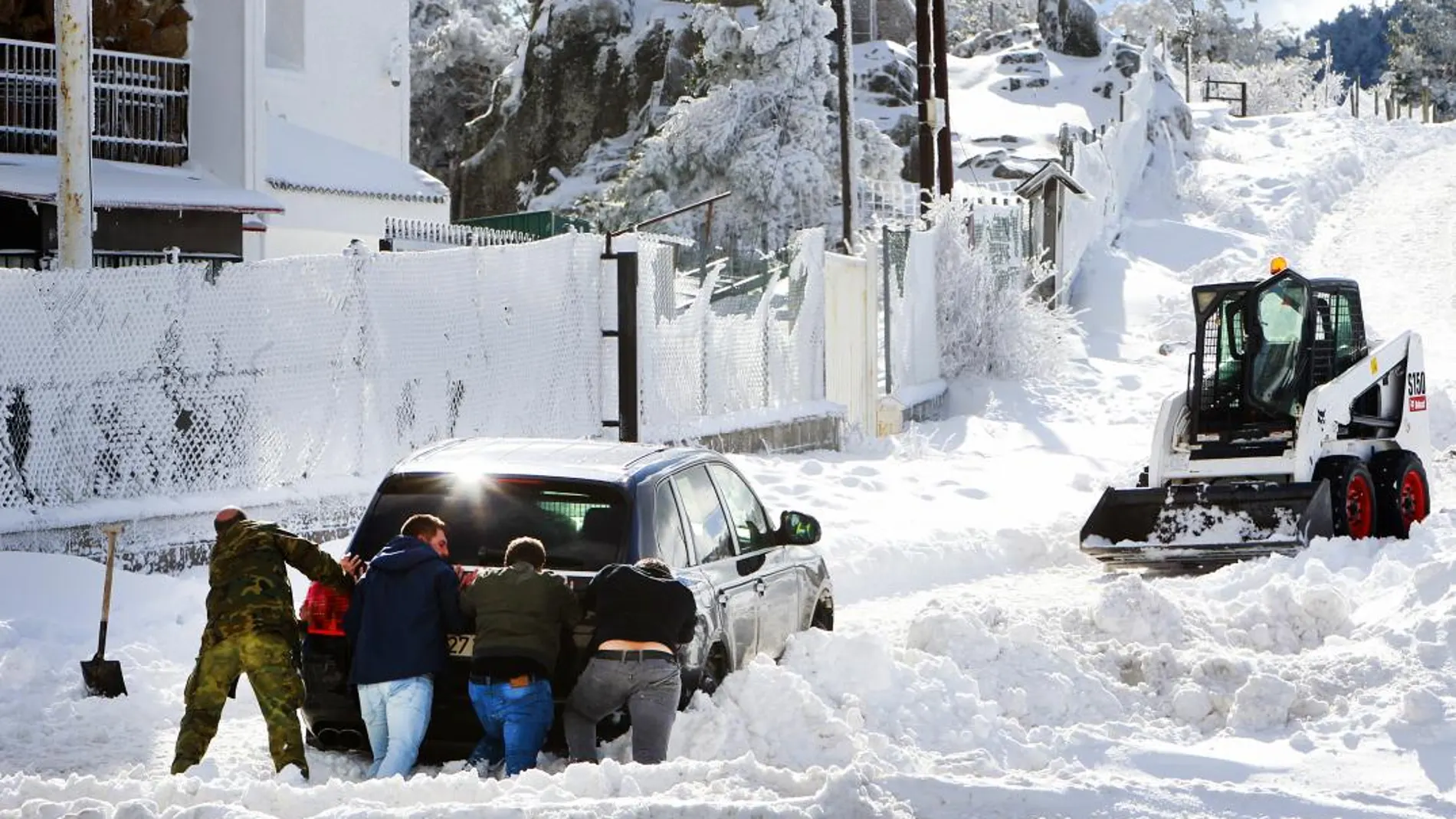 Varias personas empujan un coche atrapado por la nieve el pasado 8 de enero en Guadarrama