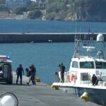 Varios médicos trasladan los cuerpos de unos inmigrantes en el puerto de la isla de Lesbos.