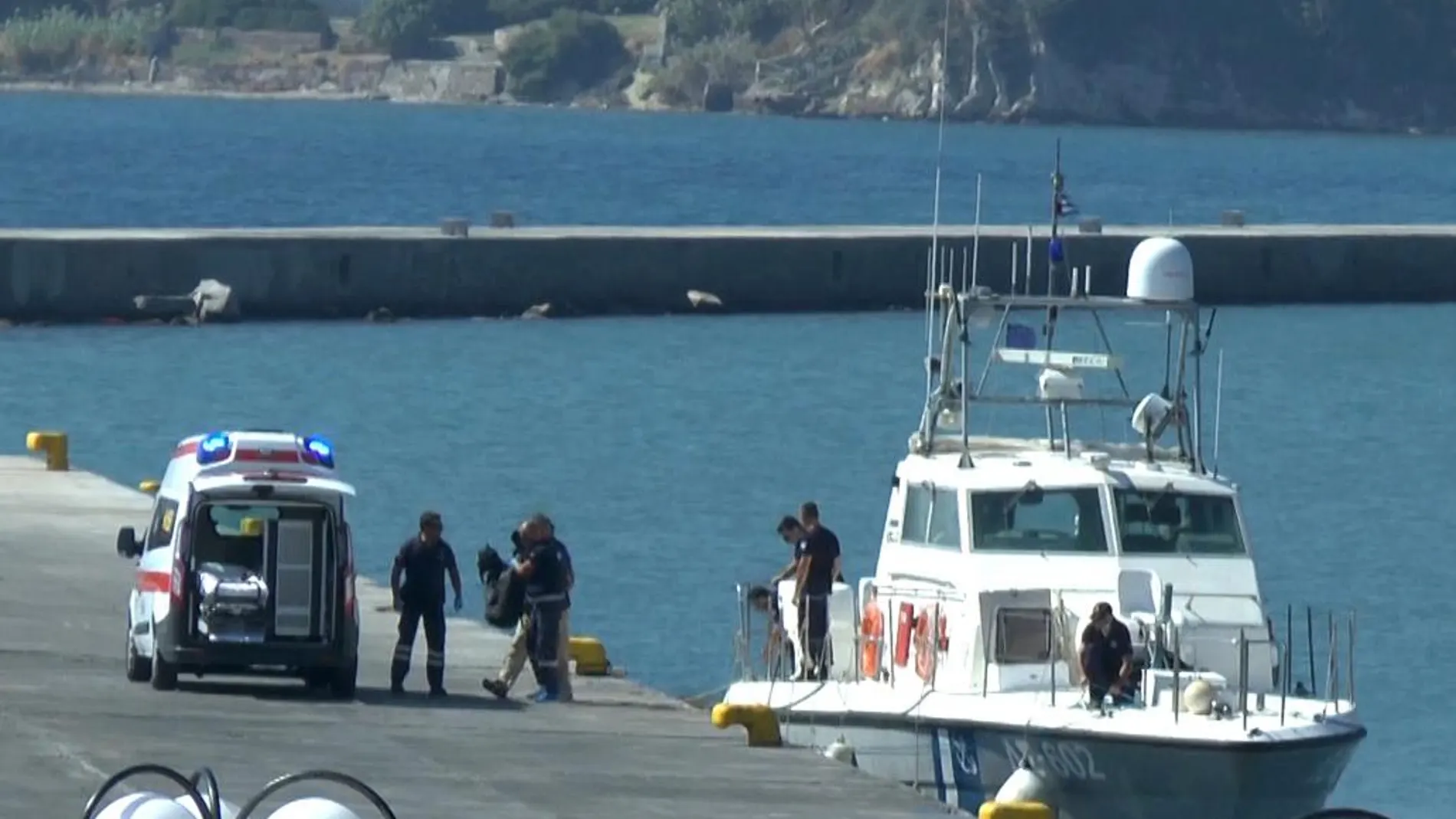 Varios médicos trasladan los cuerpos de unos inmigrantes en el puerto de la isla de Lesbos.