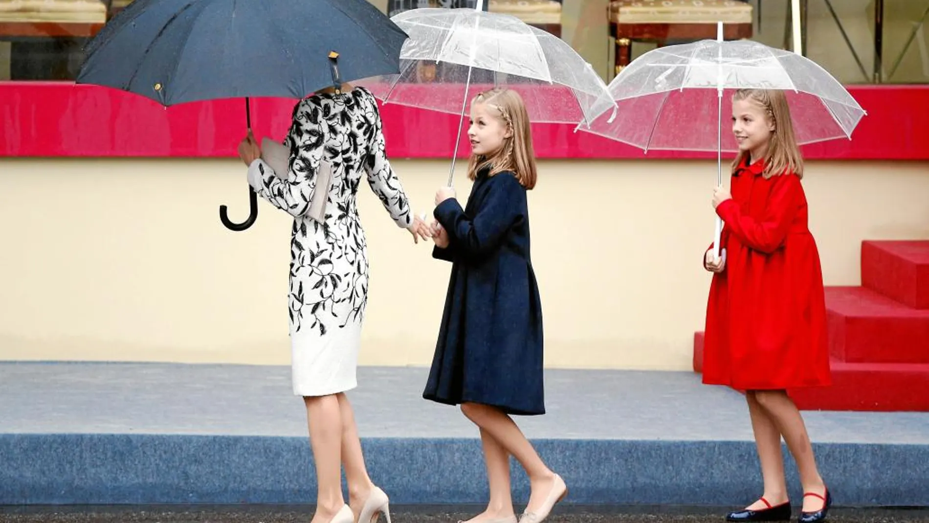 Doña Letizia junto a sus hijas, la Princesa Leonor y la Infanta Sofía, al término del desfile militar en el día de la Fiesta Nacional, celebrado en 2016.
