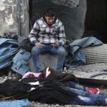 Fotografía cedida por Alepo Media Center, que muestra a un hombre que llora la pérdida de varios familiares, fallecidos tras el impacto de una bomba en el barrio de Yeb al Quebeh en Alepo,el 30 de noviembre de 2016.