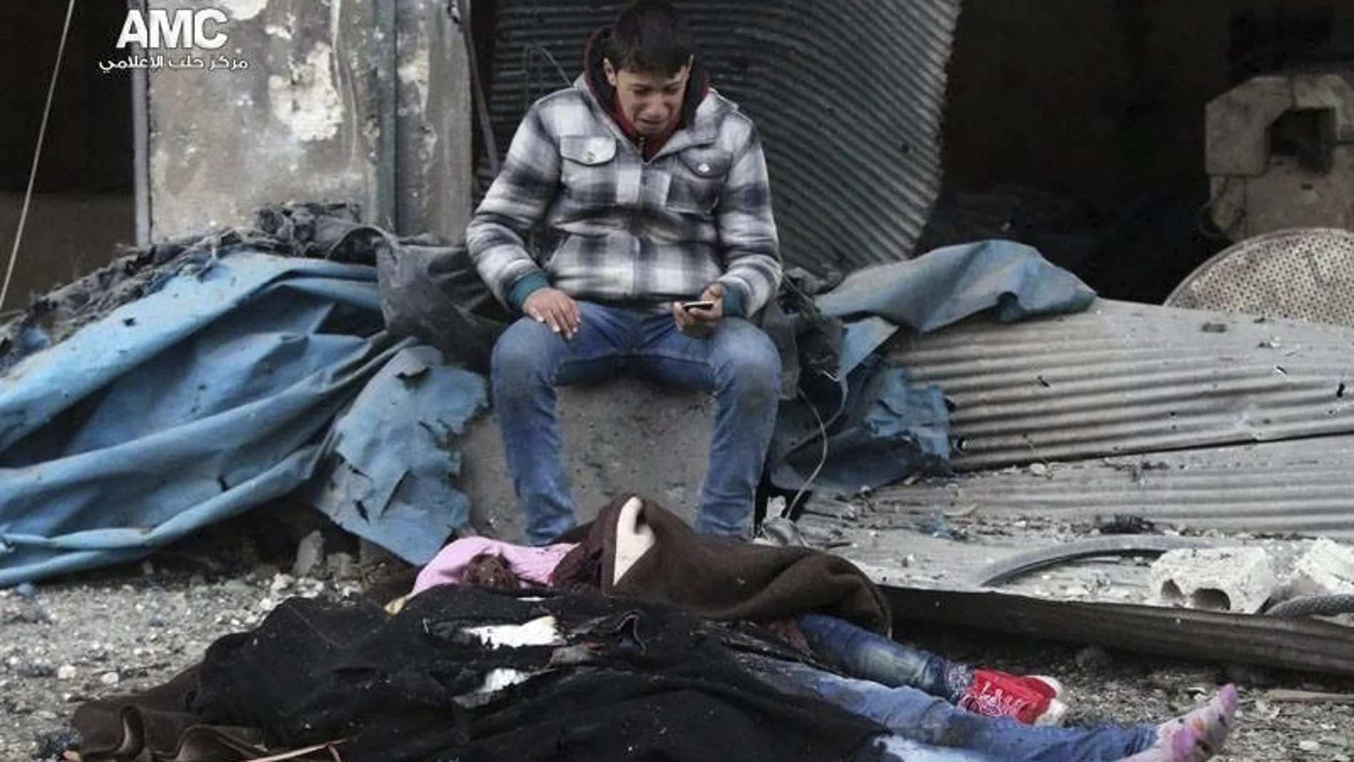 Fotografía cedida por Alepo Media Center, que muestra a un hombre que llora la pérdida de varios familiares, fallecidos tras el impacto de una bomba en el barrio de Yeb al Quebeh en Alepo,el 30 de noviembre de 2016.