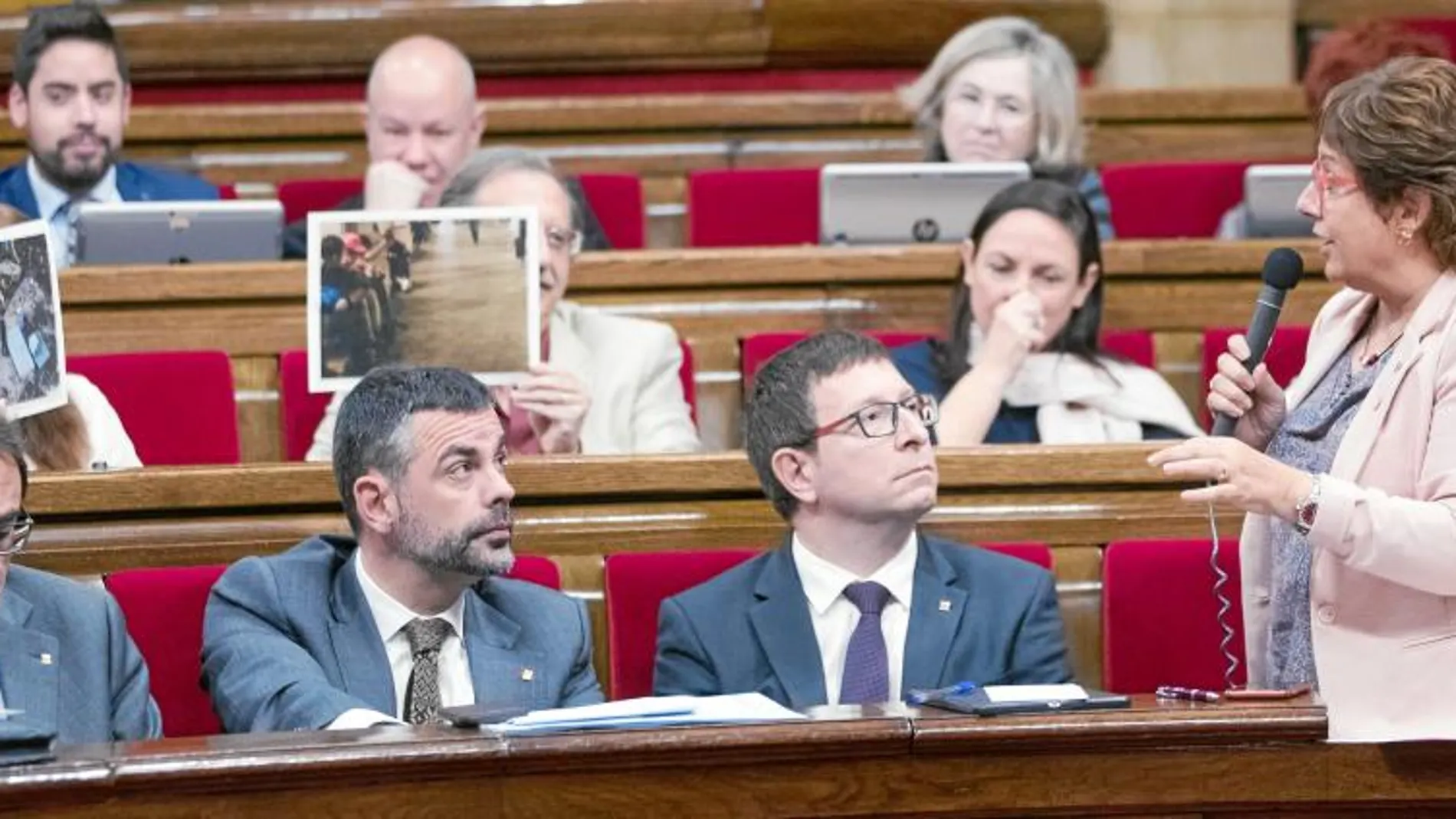 Diputados de C’s, el pasado miércoles, mostrando a la consellera Bassa imágenes de varios menores inhalando cola en las calles de Barcelona