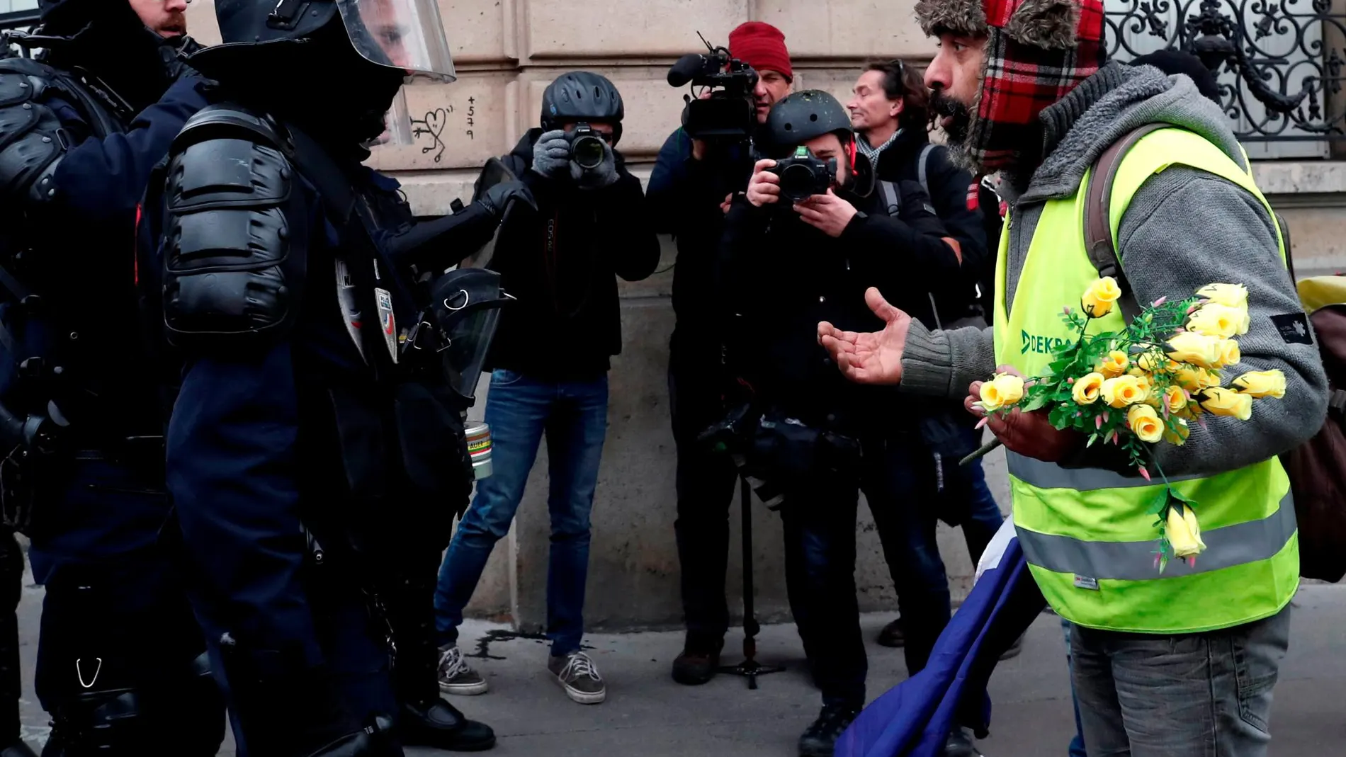 Un chaleco amarillo protesta hoy en París ante la Policía/Reuters