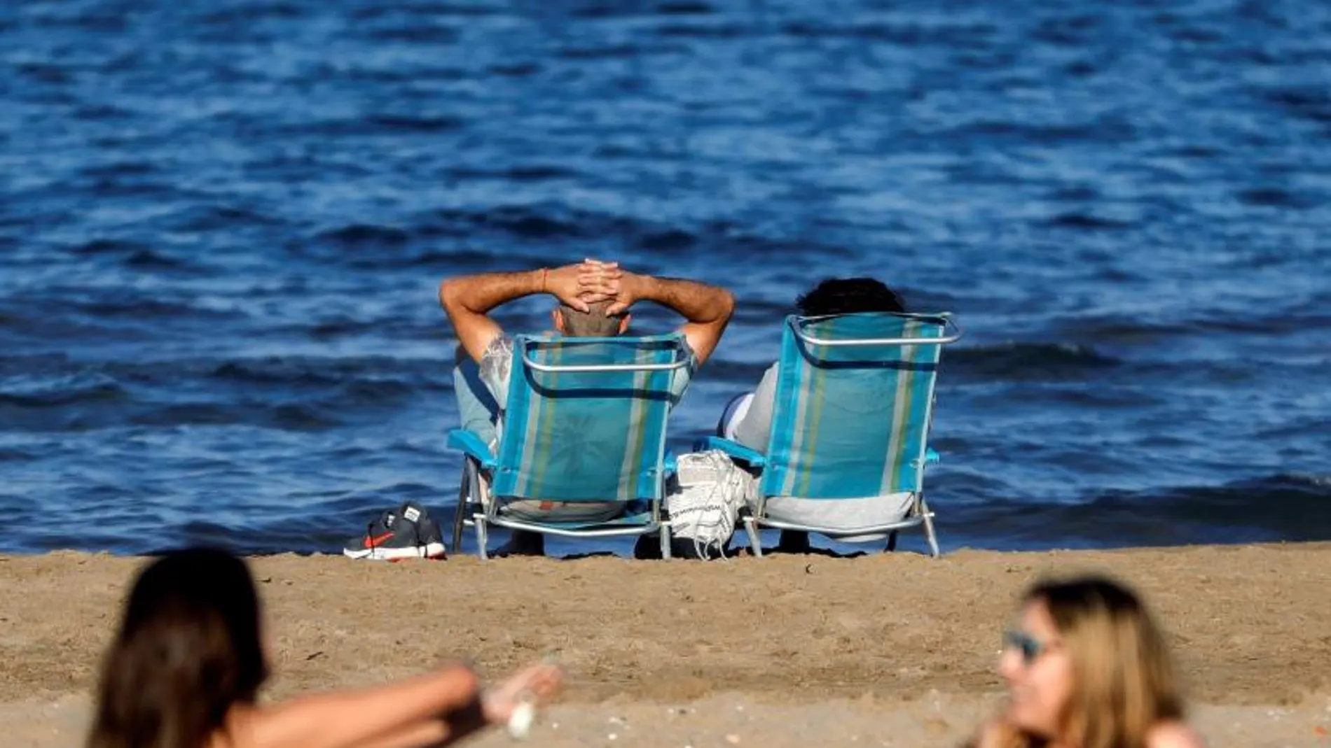 Varias personas disfrutan en la playa de la Malvarrosa del buen tiempo / Foto: Efe