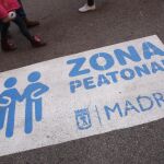 Cartel sobre la calzada que avisa de que se trata de una zona peatonal en la Gran Vía.