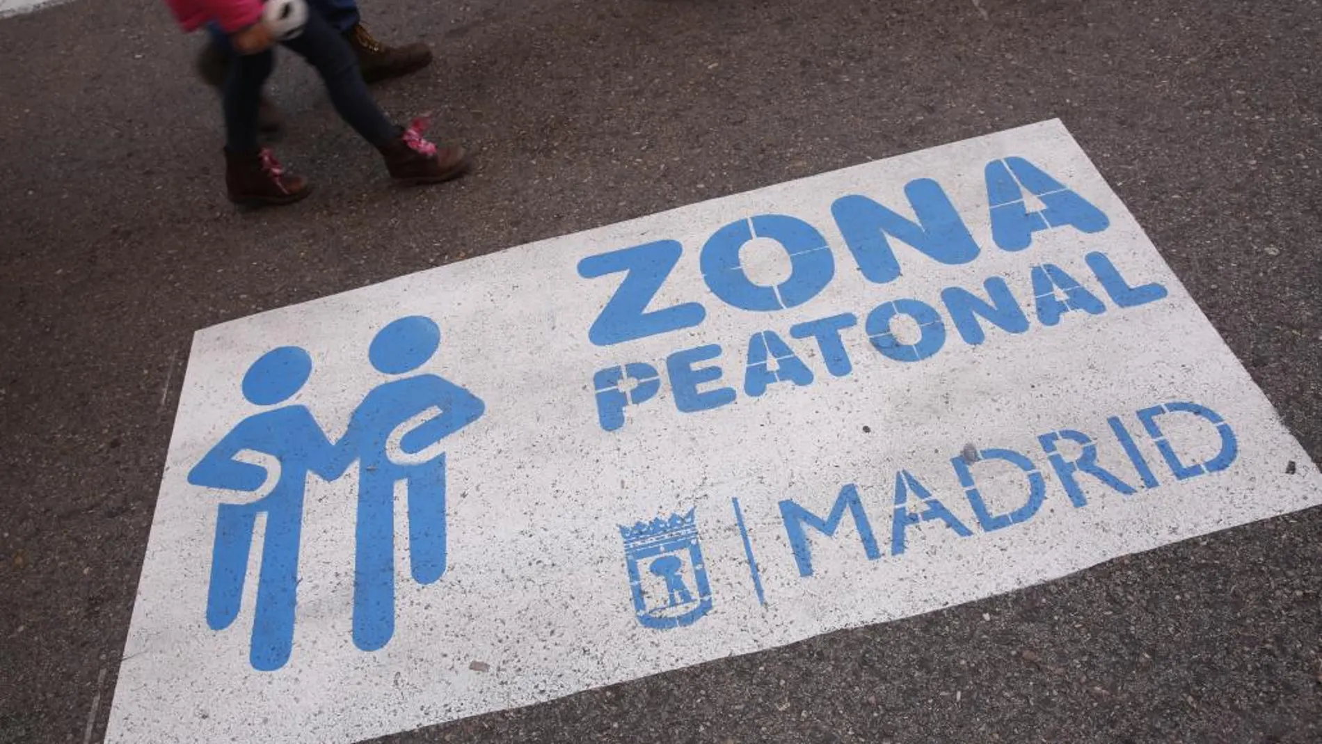 Cartel sobre la calzada que avisa de que se trata de una zona peatonal en la Gran Vía.