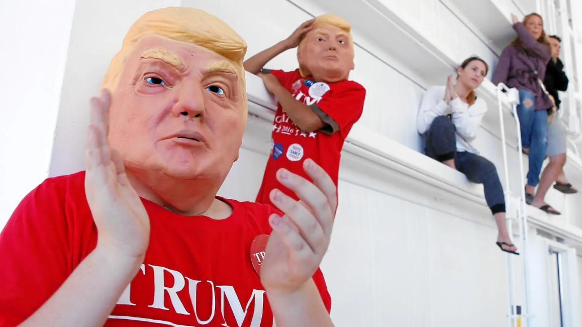Unos niños usando máscaras con el rostro de Donald Trump escuchan al candidato republicano en un mitin en Carolina del Norte el sábado