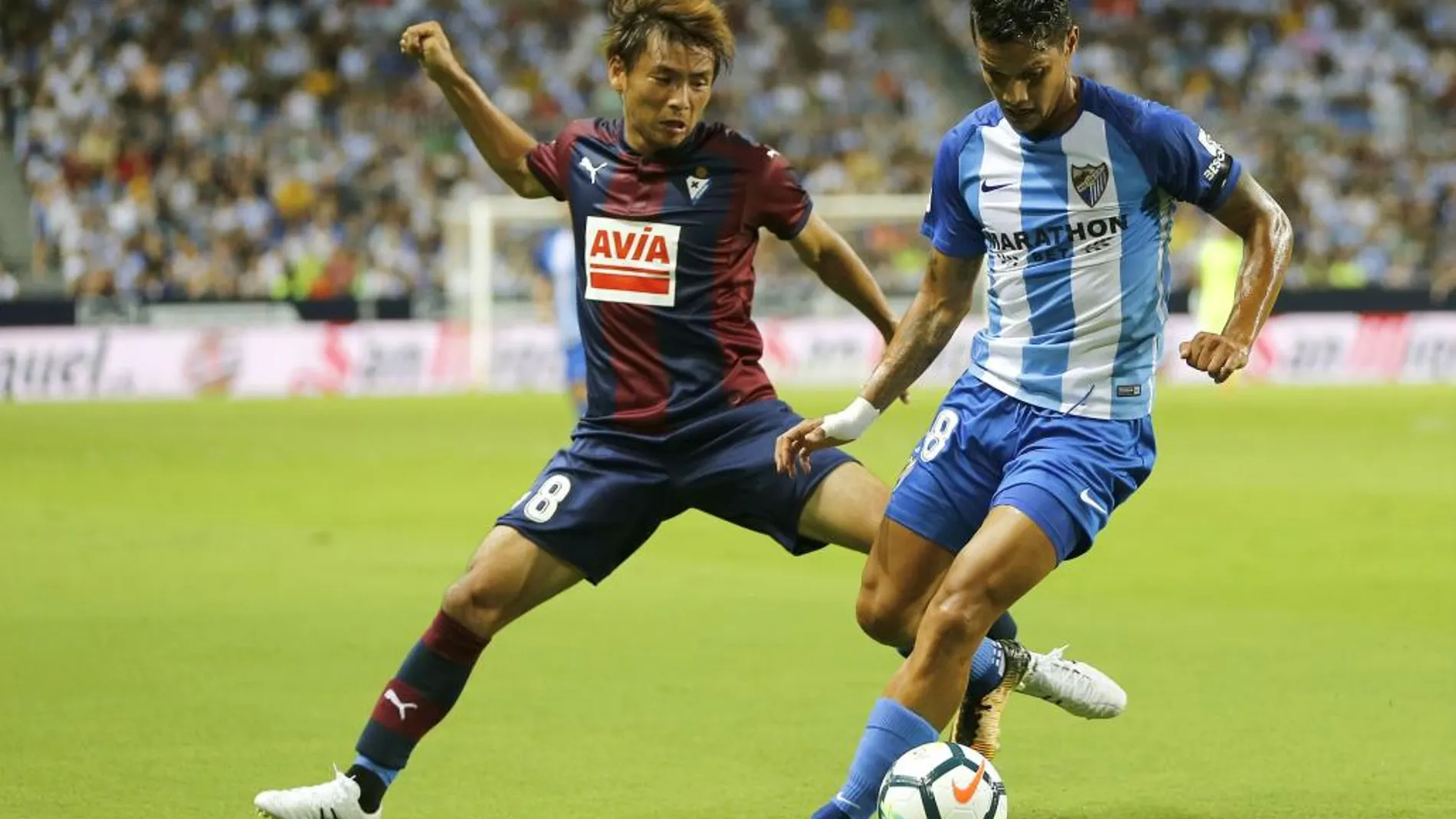 El defensa venezolano del Málaga Roberto Rosales (d) lucha por el balón ante el centrocampista japones del Eibar Takashi Inui