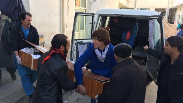 Afganos trasladan el cadáver de una víctima del ataque suicida perpetrado en una madrasa