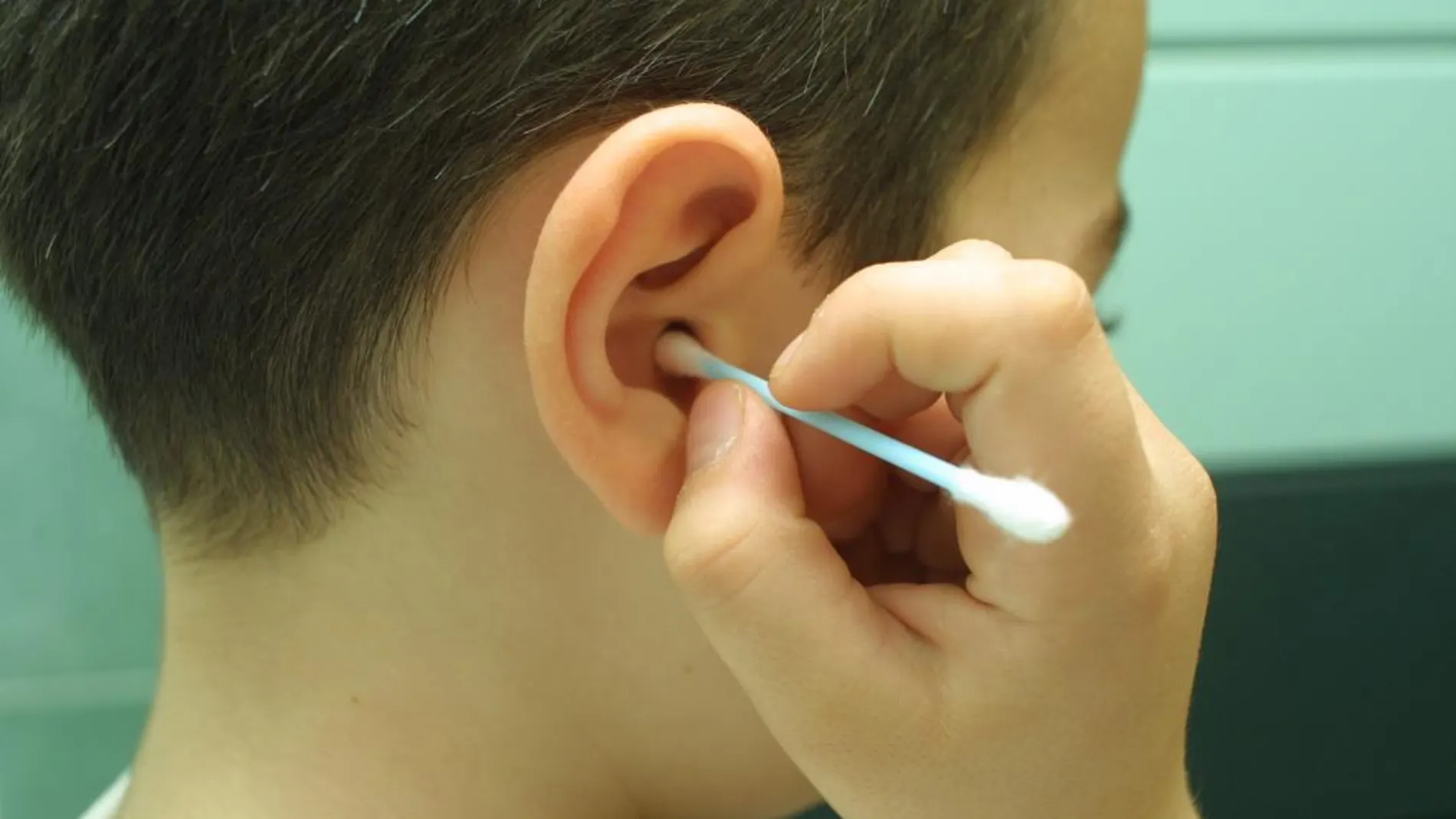 Un niño utilizando un bastoncillo para los oídos