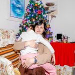 Yanet, con su hija en brazos, y sus padres llevan todo el año escogiendo los tapones más bonitos para adornar su árbol de Navidad