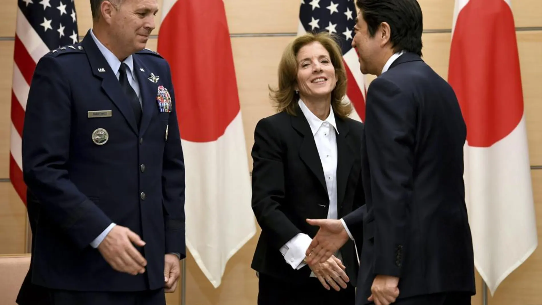 El primer ministro japonés, Shinzo Abe (d), saluda al comandante de las Fuerzas de EEUU en Japón, en presencia de la embajadora estadounidense en Japón, Caroline Kennedy.