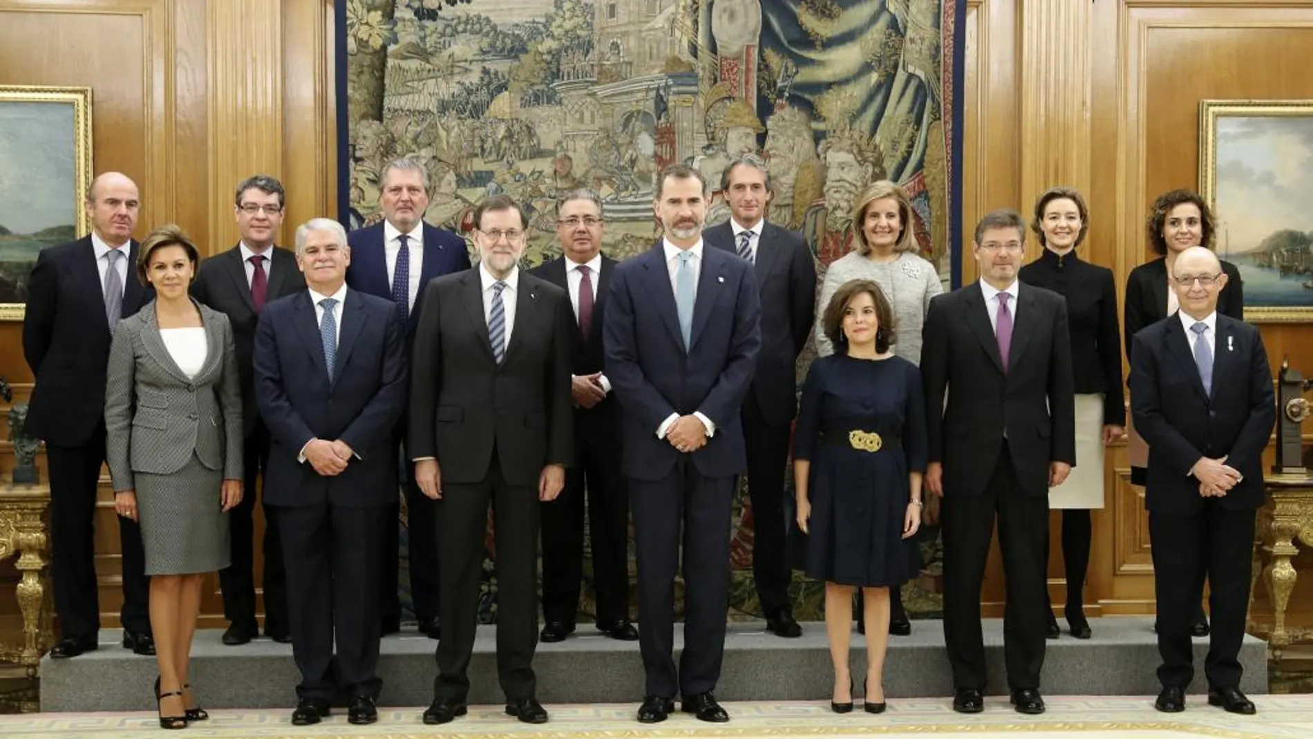 El rey Felipe VI posa con el jefe del Ejecutivo, Mariano Rajoy, y los 13 ministros de su nuevo Gobierno, que han jurado o prometido hoy sus cargos ante él en una ceremonia celebrada en el Palacio de la Zarzuela