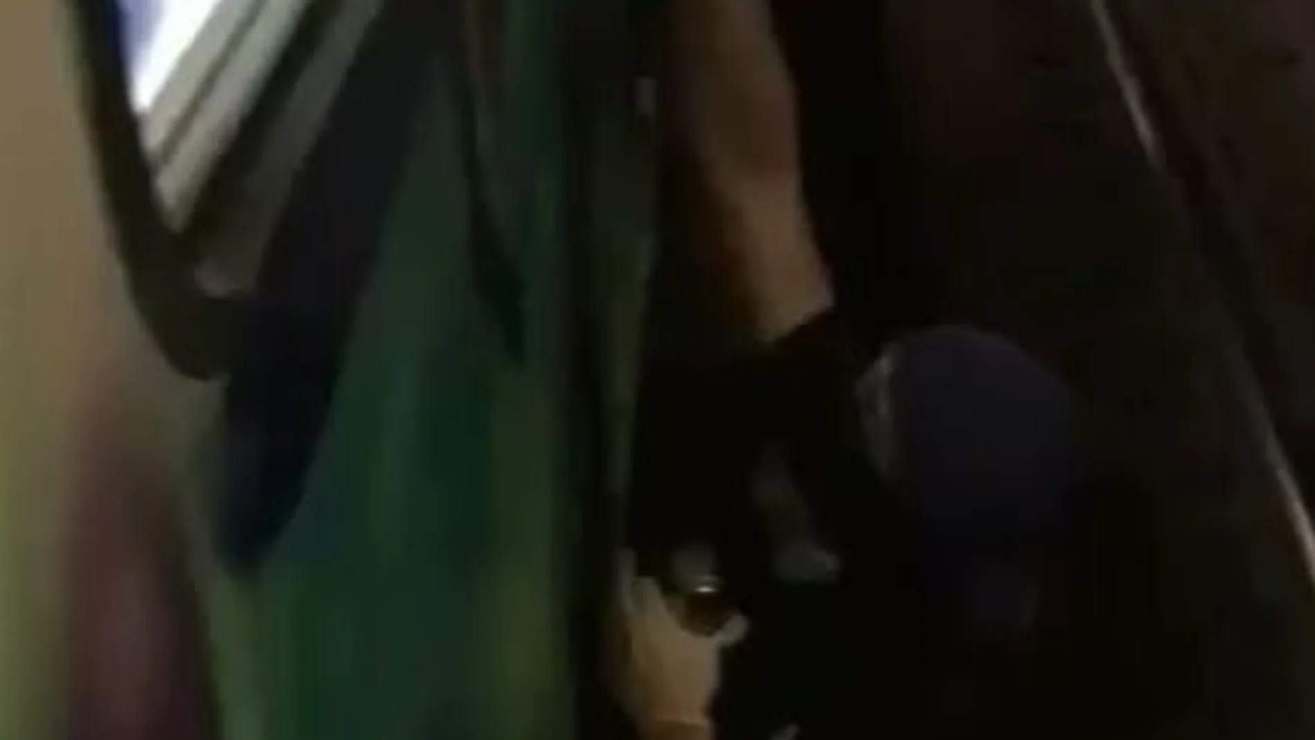 Uno de los encapuchados haciendo un graffiti.