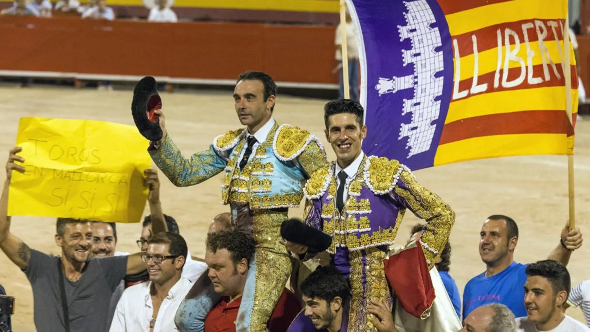 Los diestros Enrique Ponce (i), que cortó tres orejas, y Alejandro Talavante, que logró dos, salieron a hombros en el festejo nocturno celebrado hoy en la plaza de toros de Palma de Mallorca.