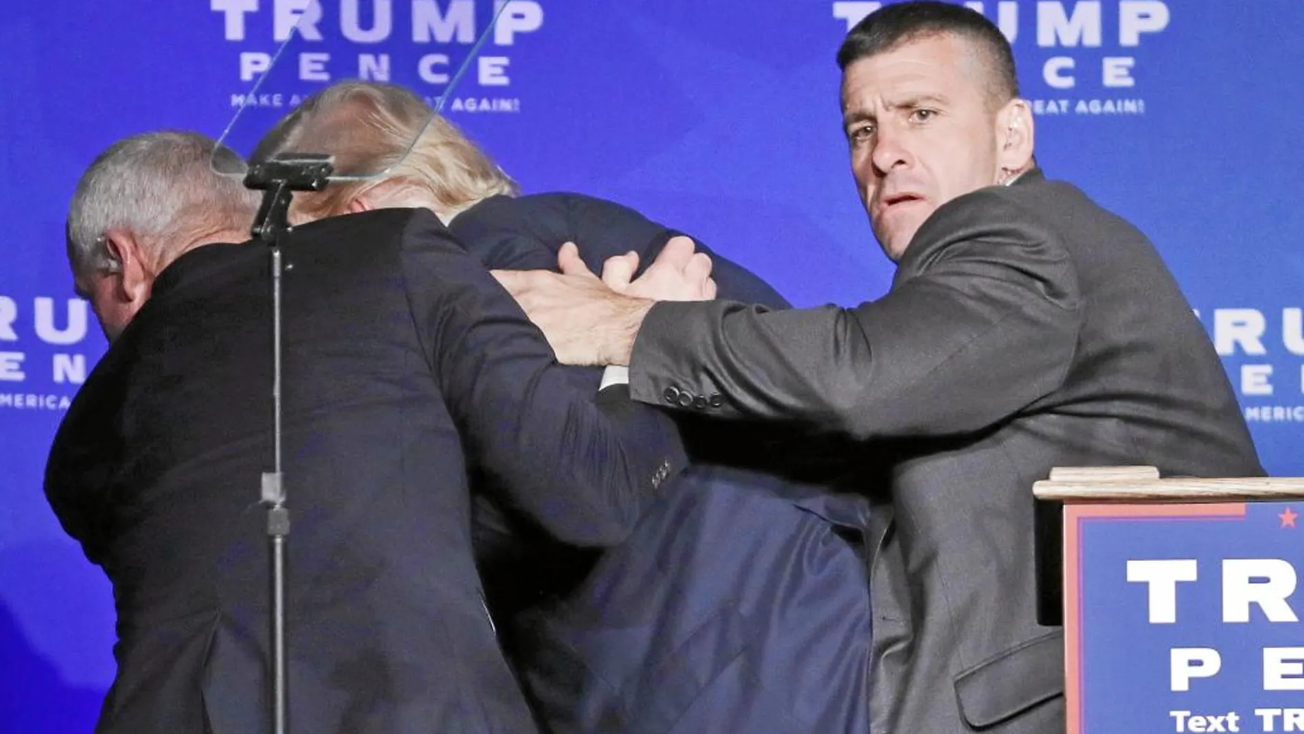 Dos agentes de seguridad evacúan a Donald Trump durante un mitin electoral, el sábado en Reno (Nevada), ante la sospecha de un hombre armado