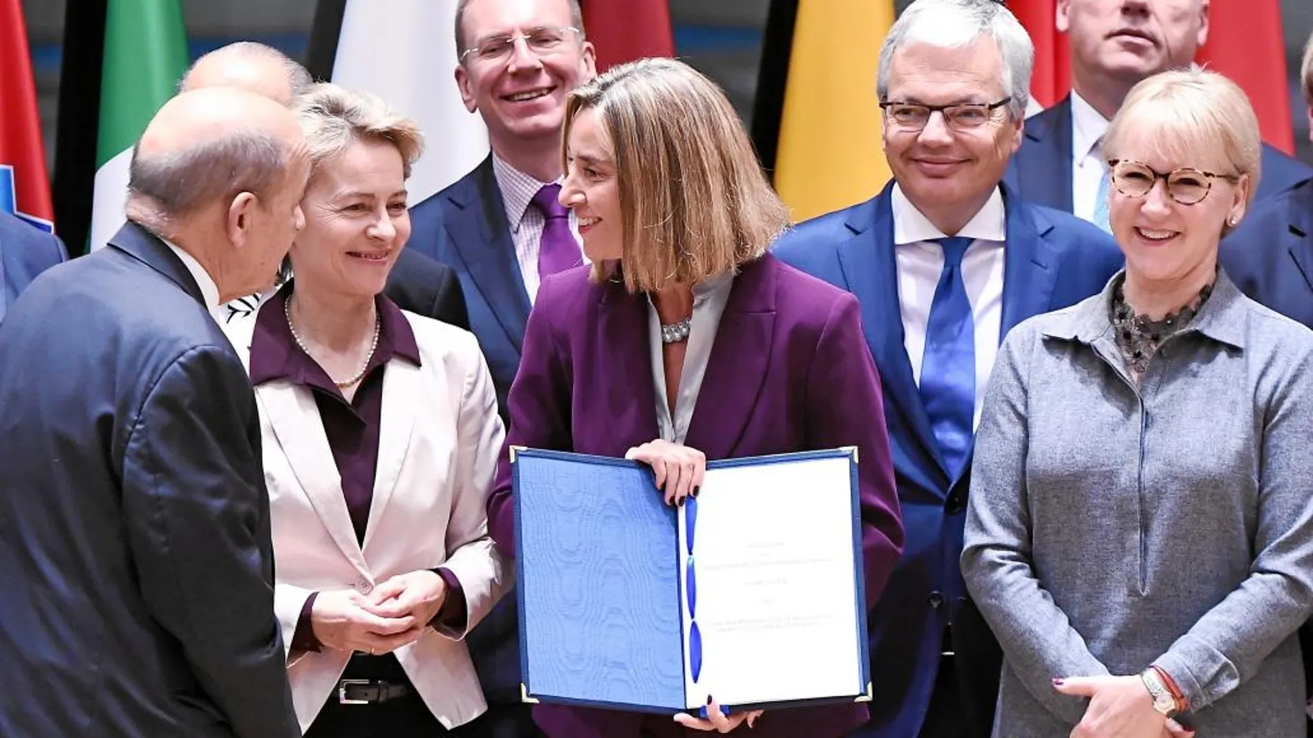La Alta Representante, Federica Mogherini, rodeada por los ministros de Defensa, muestra la firma de la PESCO