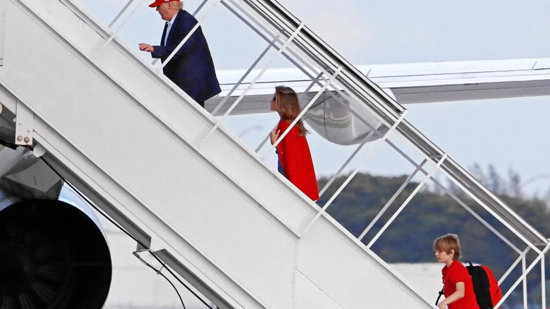 Trump, junto a su esposa y su hijo Barron, sube a su avión privado en Florida