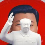 Una escultura de Mao Zedong enfrente de un souvenir con la imagen del actual presidente chino, Xi Jinping, desplegados en una tienda junto a la plaza de Tiananmen, en Pekín