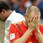 Andres Iniesta se lamenta tras la eliminación de España. Detrás, Fernando Hierro. Efe