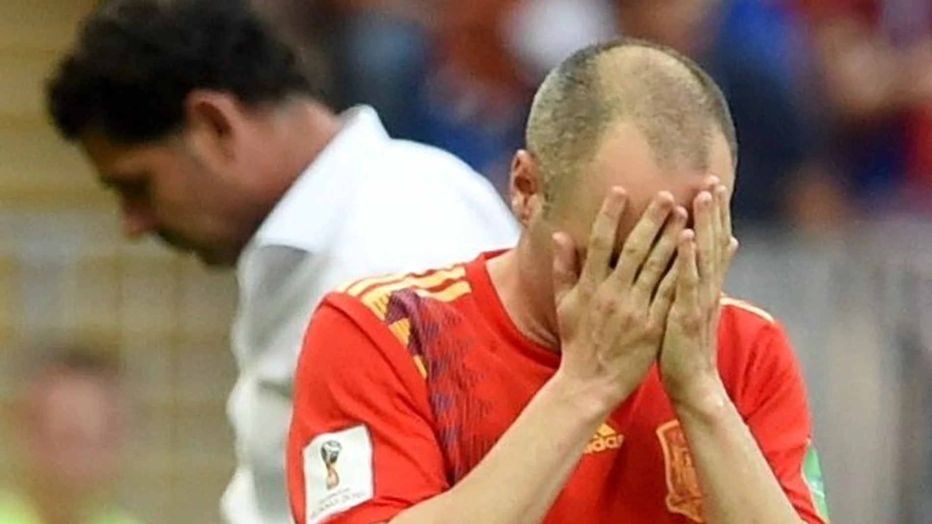 Andres Iniesta se lamenta tras la eliminación de España. Detrás, Fernando Hierro. Efe