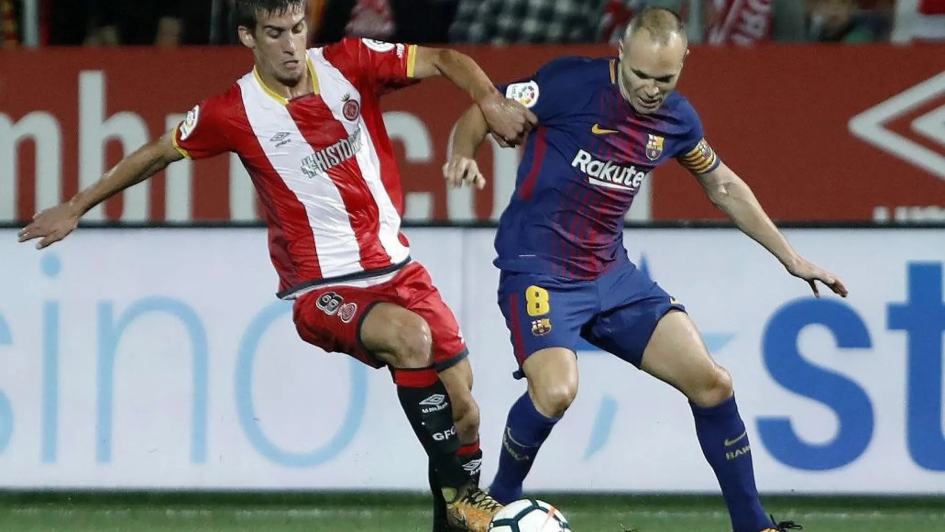 El jugador del Bracelona Andrés Iniesta, intenta avanzar ante la presencia del jugador del Girona Ramalho