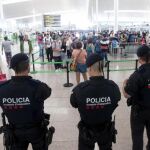 Agentes de los Mossos d'Esquadra controlan de los accesos a las puertas de embarque en el Aeropuerto de El Prat.