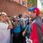 El ex candidato Henrique Capriles saluda a un grupo de venezolanos esperando en una larga fila, ayer