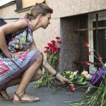 Una mujer deja flores en Barcelona