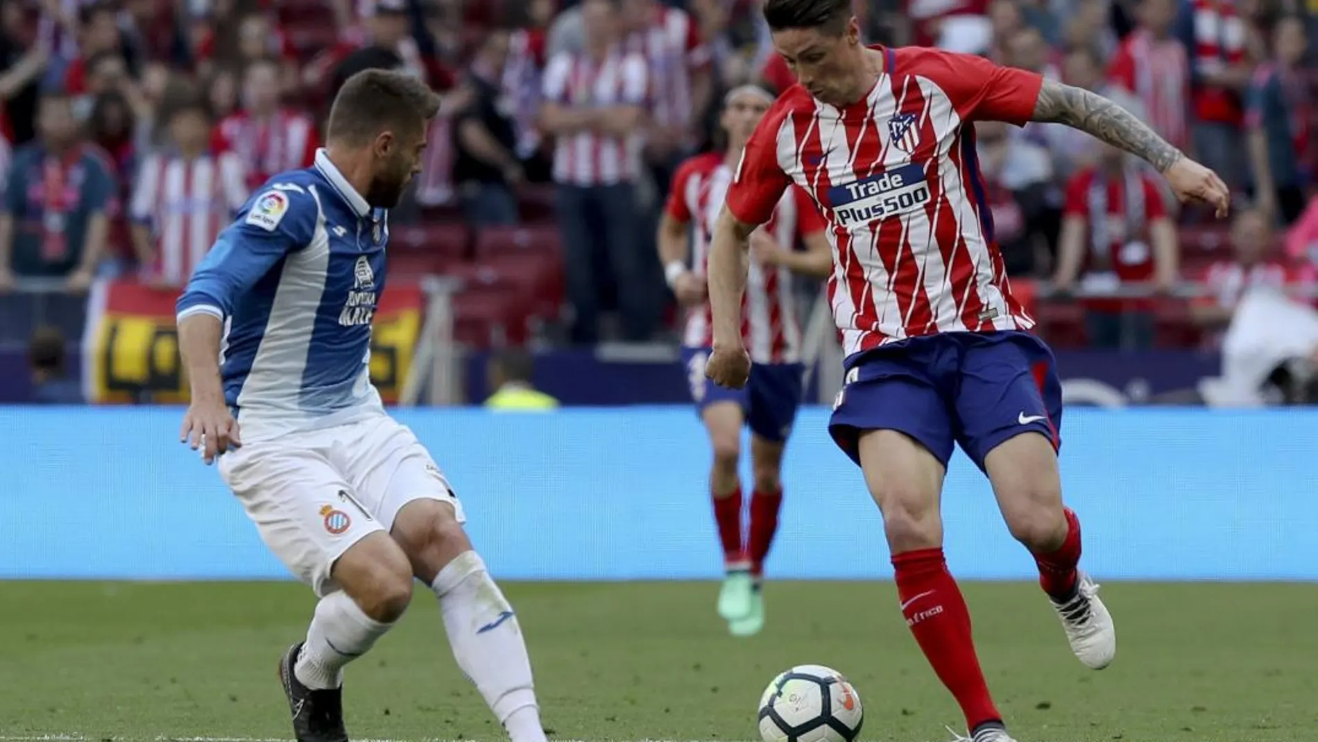 El delantero del Atlético de Madrid, Fernando Torres pelea un balón con el centrocampista del Espanyol, David López / Foto: Efe