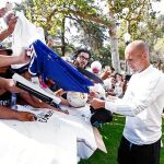 Zidane firma autógrafos en la concentración del Madrid