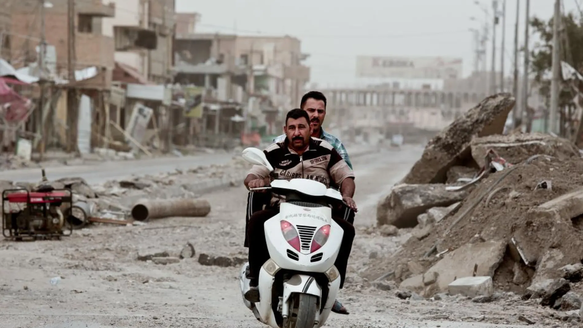 Dos hombres en una moto entre las ruinas de la ciudad de Mosul