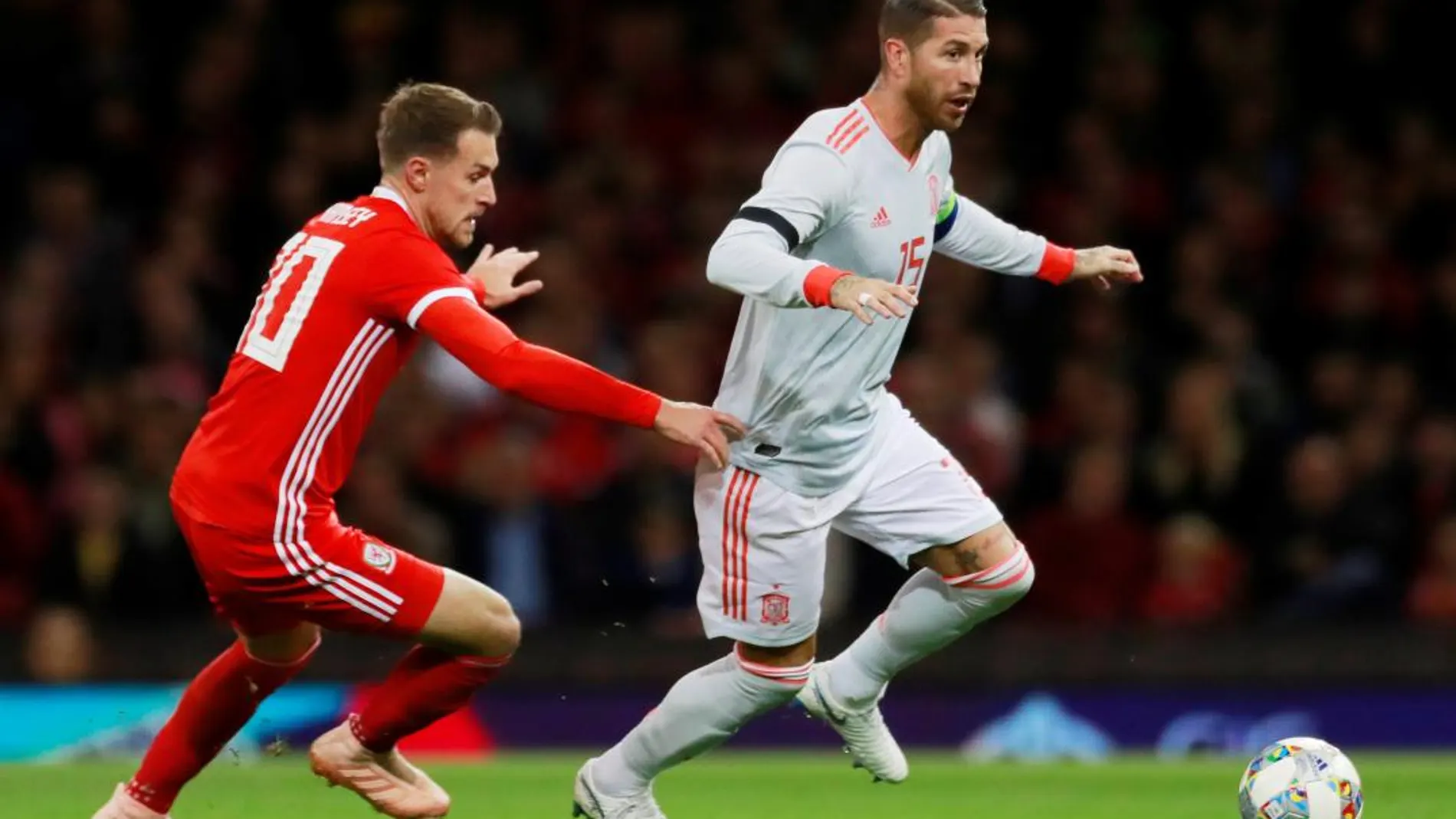 Sergio Ramos disputa un balón en presencia del galés Ramsey / Reuters