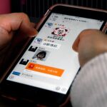 Una mujer utiliza su teléfono móvil para acceder a un grupo ‘kua kua’ (grupos de adulación) de la Universidad Jiatong de Xi’an / Efe