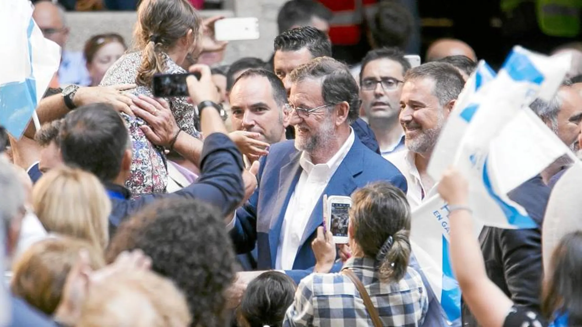 El presidente del Gobierno en funciones, Mariano Rajoy, saluda a algunos de los más de 12.000 simpatizantes que se dieron cita ayer en Pontevedra